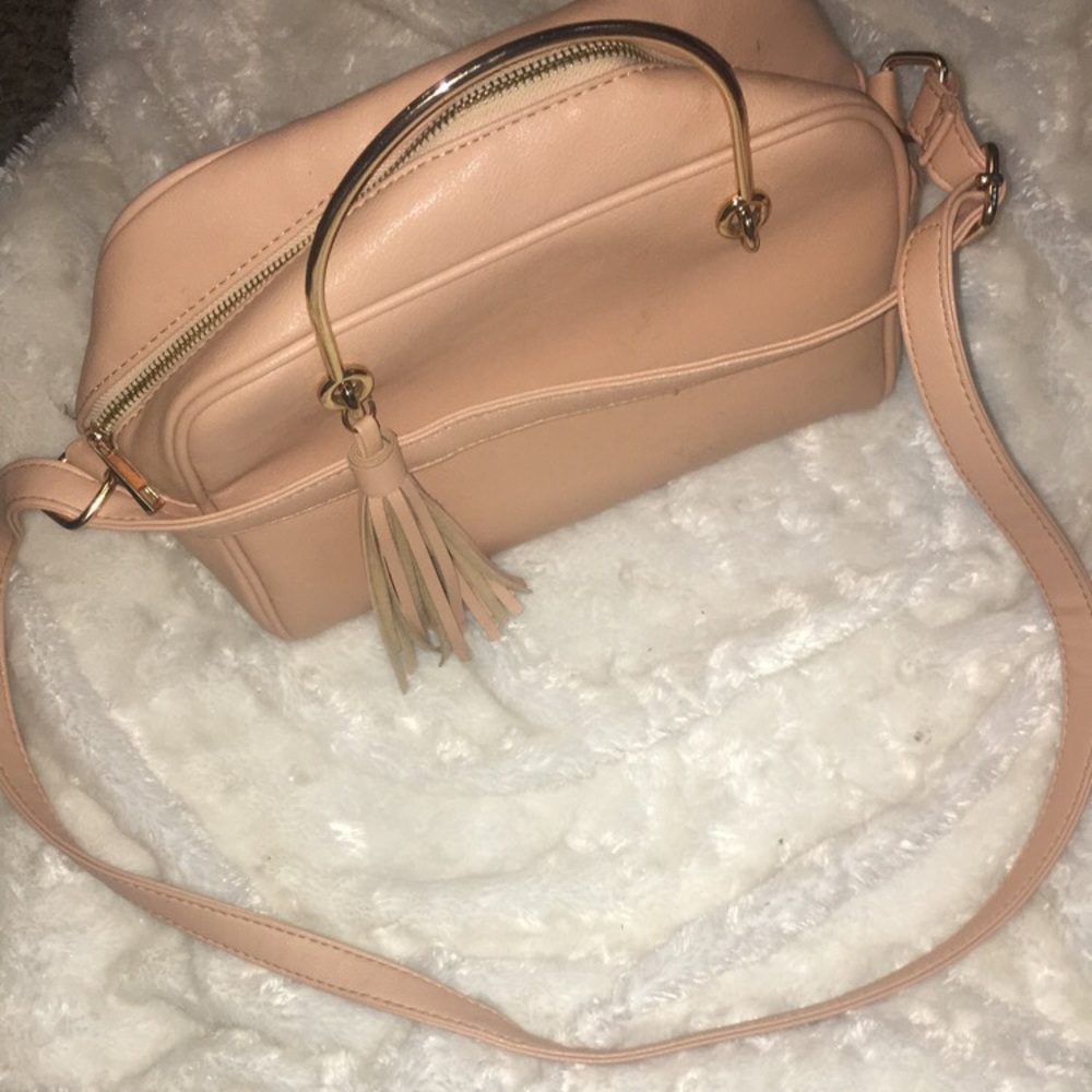 A purse with handles on it’s a peachy color